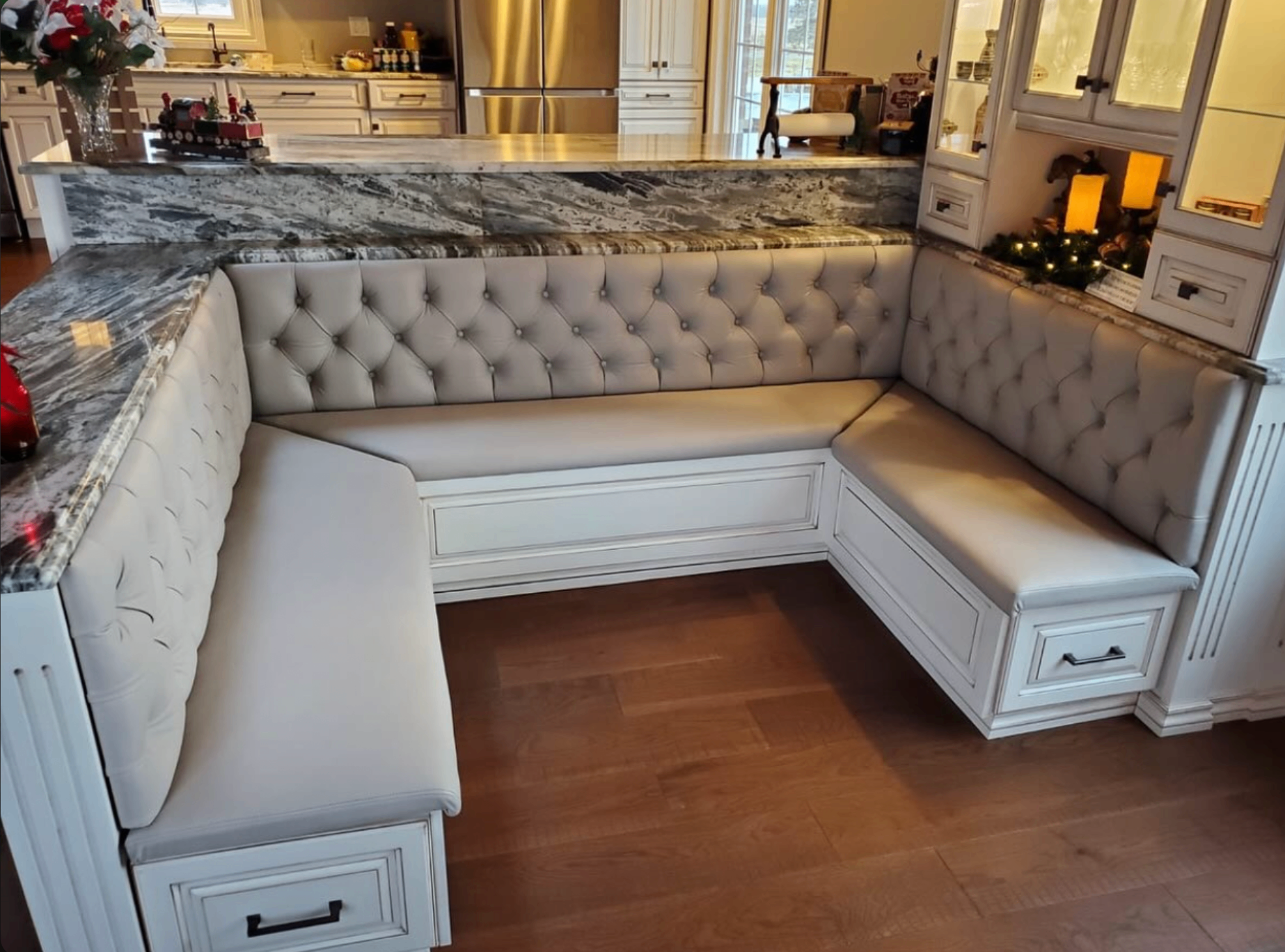 Custom built-in L-shaped kitchen banquette with tufted upholstery