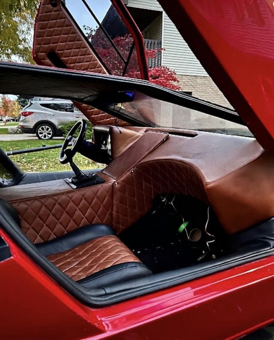 Interior of a red vehicle featuring cognac diamond-stitched leather dash and seats