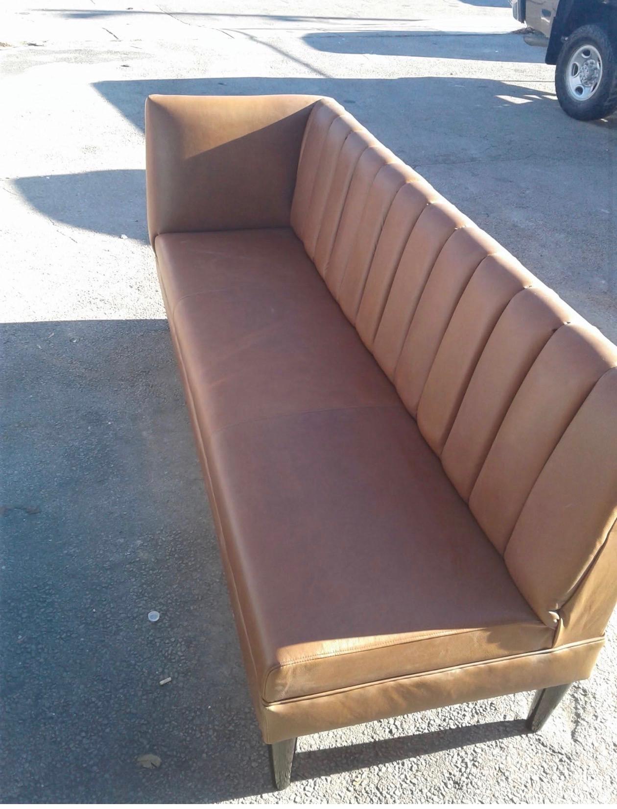 Long tan leather bench with channel-tufted backrest